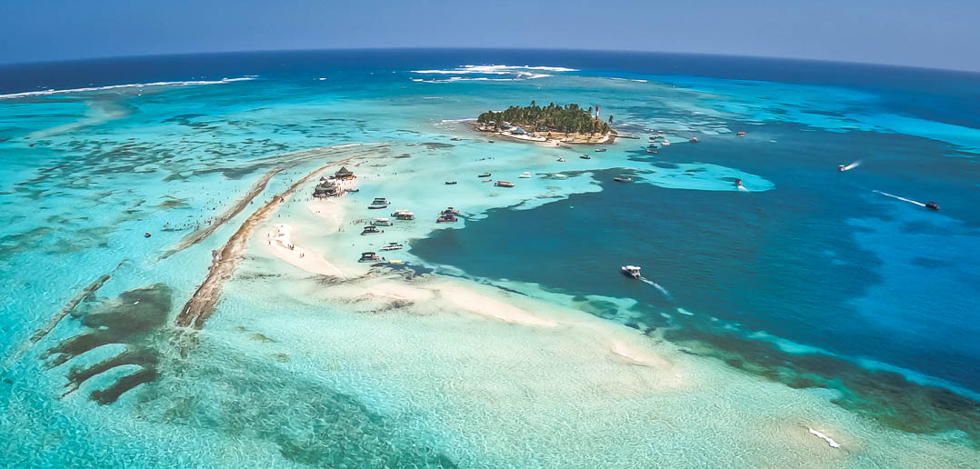 Orla de San Andrés com coqueiros e mar de sete cores ao fundo